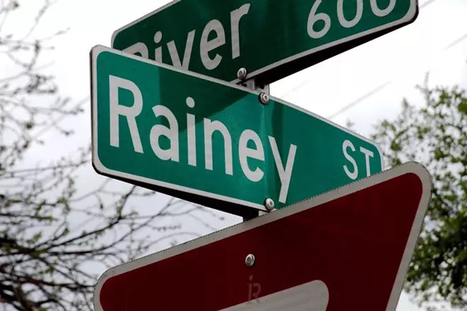A sign shows the cross streets of Rainey and River in Austin.