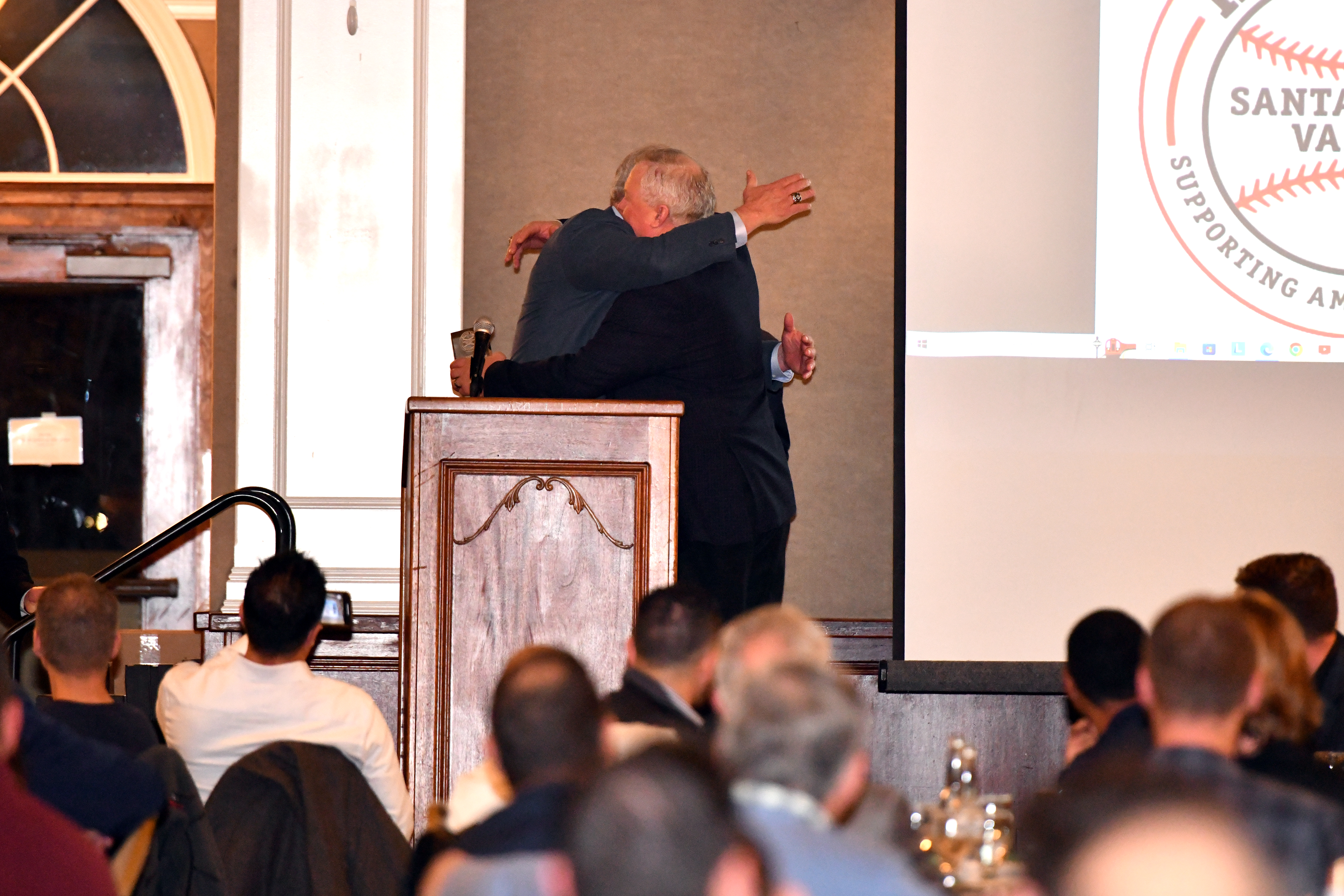 MLB umpires Ted Barrett, left, and Bill Miller, a Santa Cruz native, embrace after Miller was honored at the 37th annual Hot Stove of Santa Clara Valley Banquet at Villa Ragusa in Campbell on Tuesday.  (Brandon Vallance - Santa Cruz Sentinel)