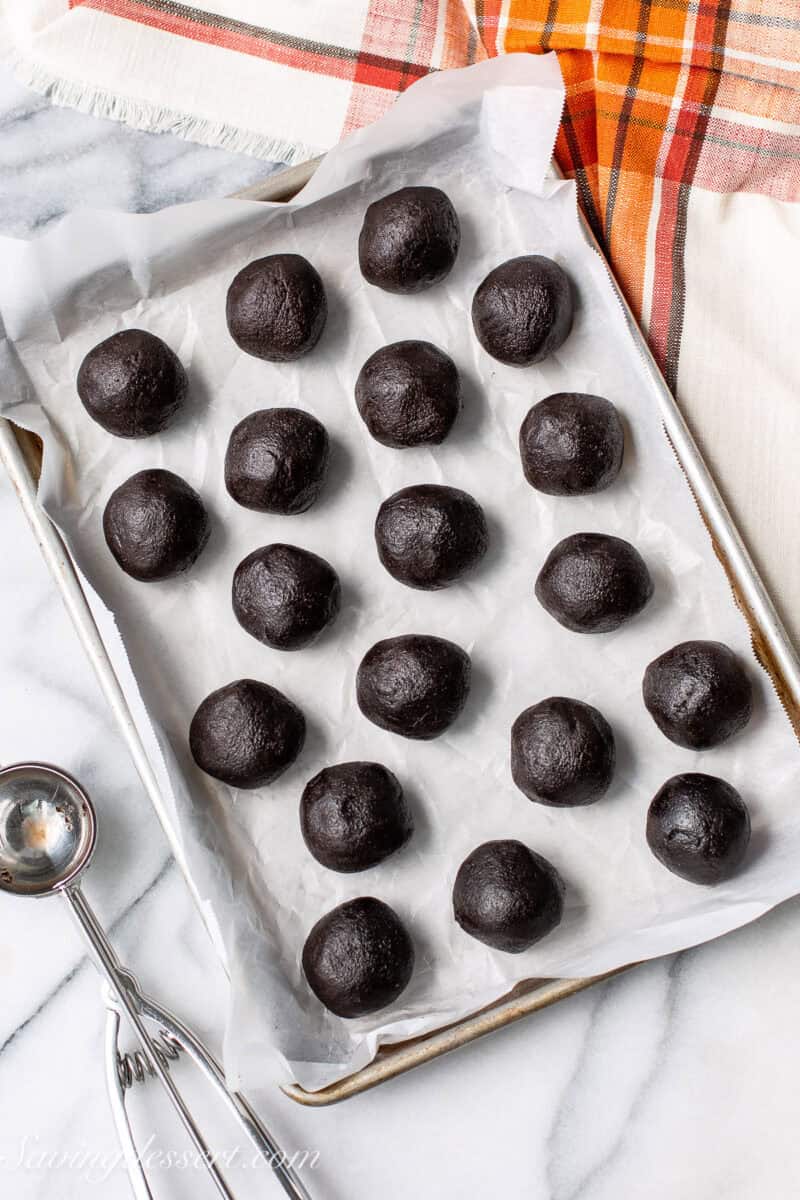 Chocolate cookie dough balls on a tray.