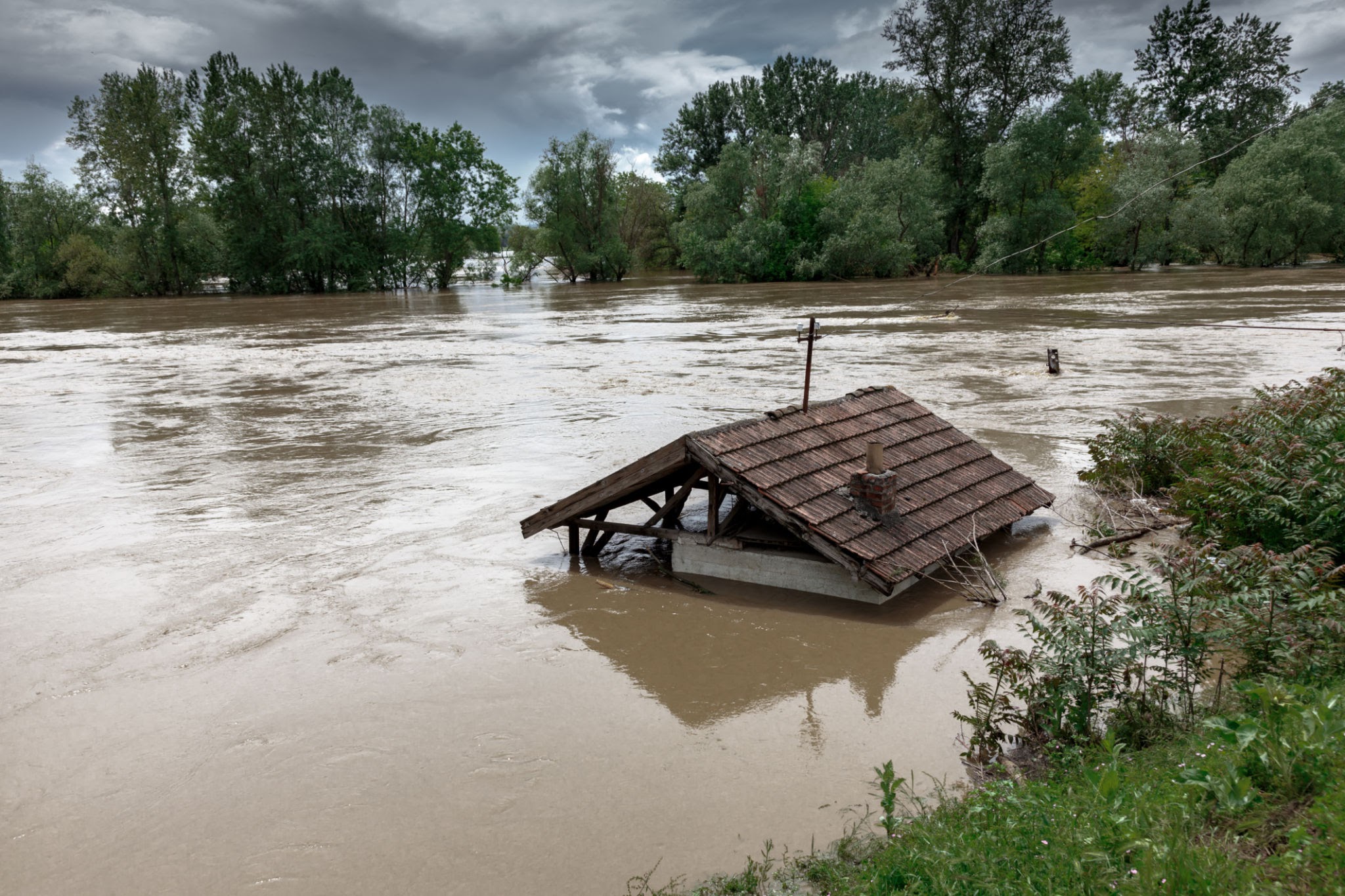 Flood water flooded house, only roof can bu seen