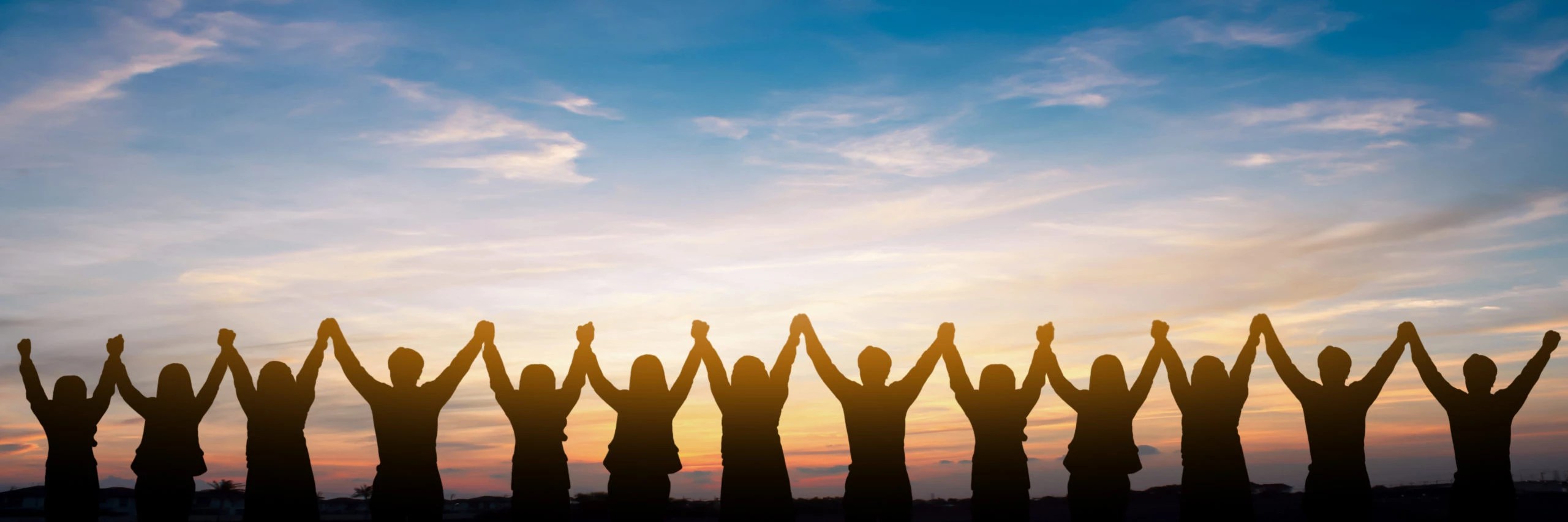 Silhouette of group happy business team making high hands over head in beautiful sunset sky evening time for business success and teamwork concept in company