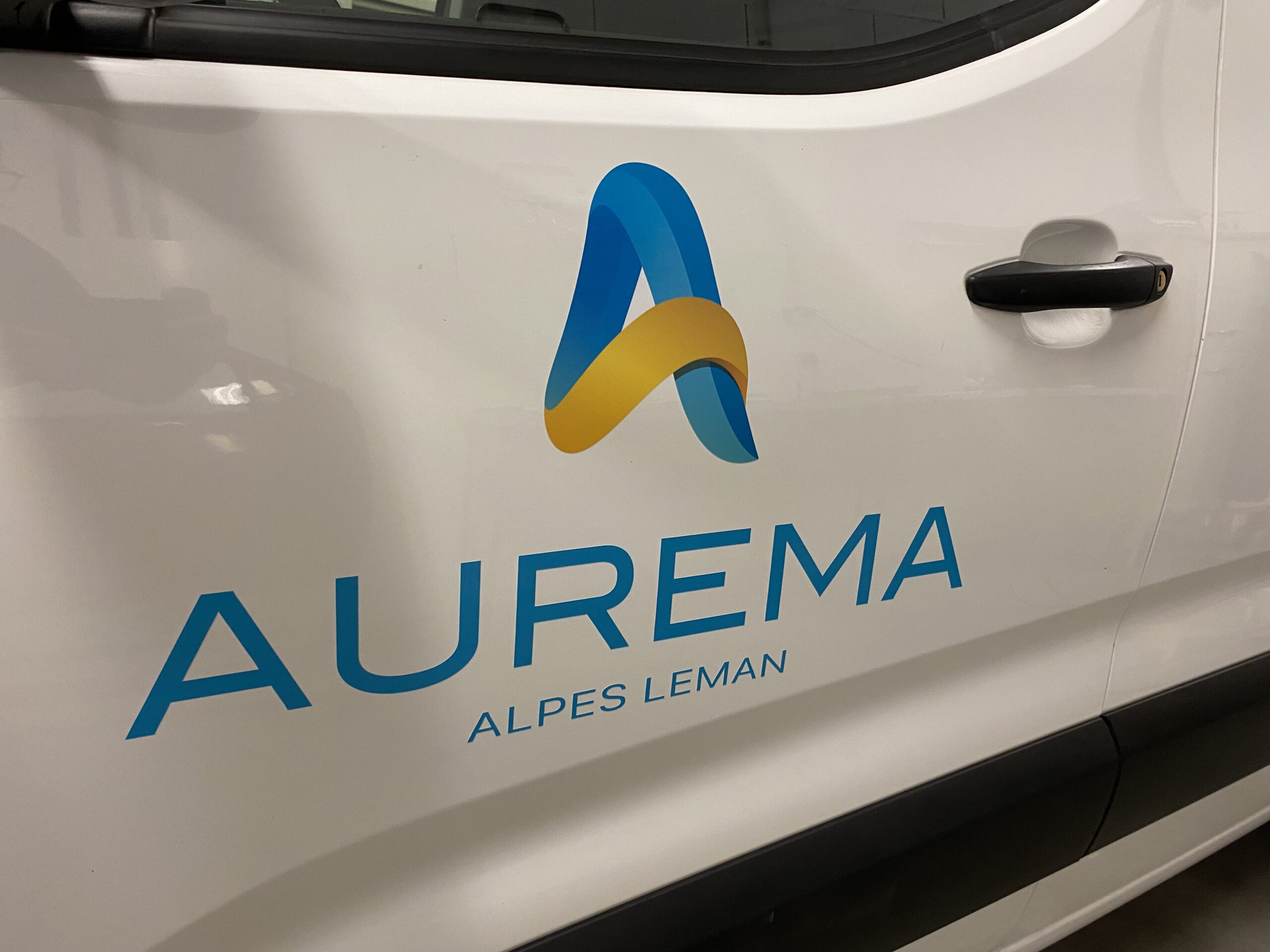 Marquage, vue rapprochée, sur un véhicule utilitaire peugeot avec le logo de l'entreprise aurema