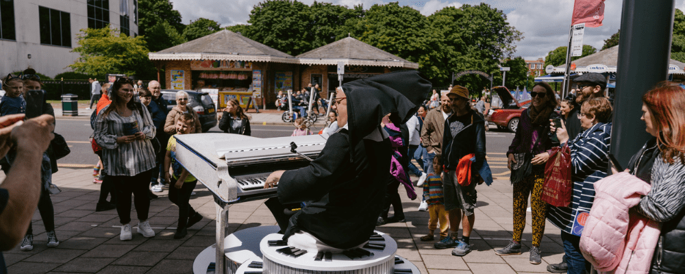 Musical Ruth (a nun playing a motorised piano) entertaining the group surrounding them on the path outside The Embassy Theatre main entrance.
