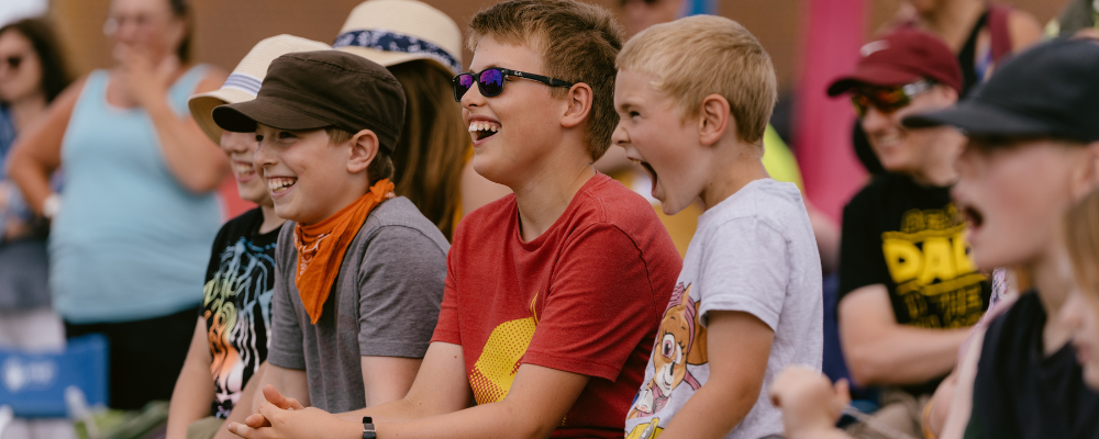 A close-up of four children the audience laughing