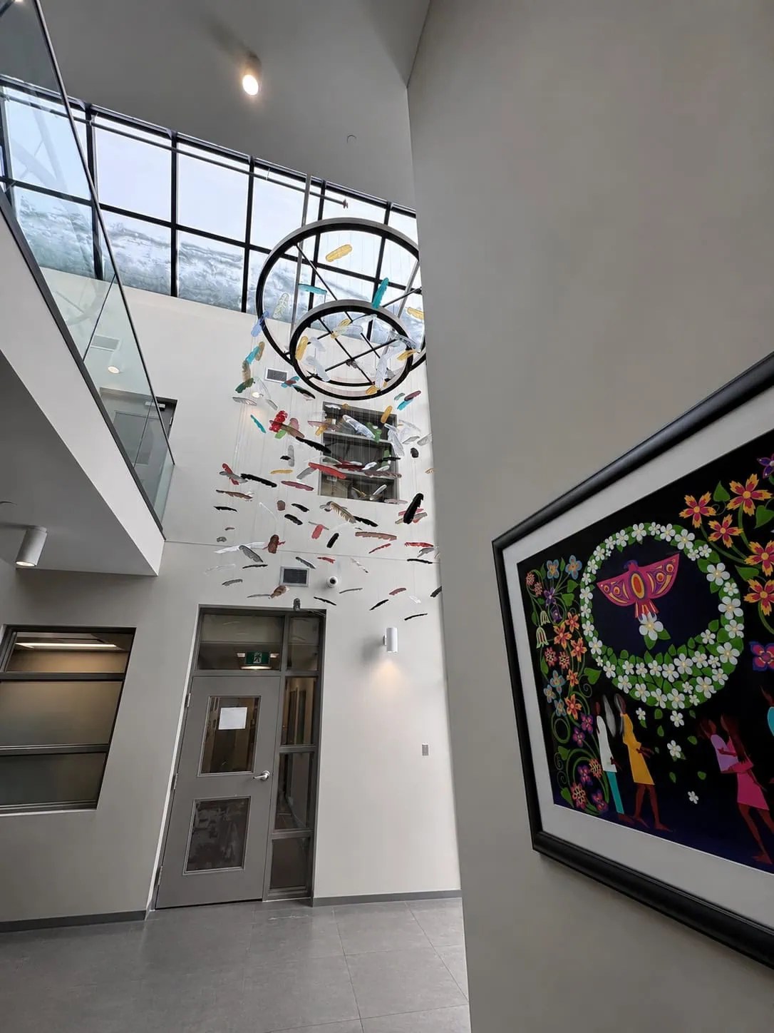 Wide atrium view of Chromatic Canopy showing full drop height of glass feather installation across multi-storey space, SOAHAC London Ontario