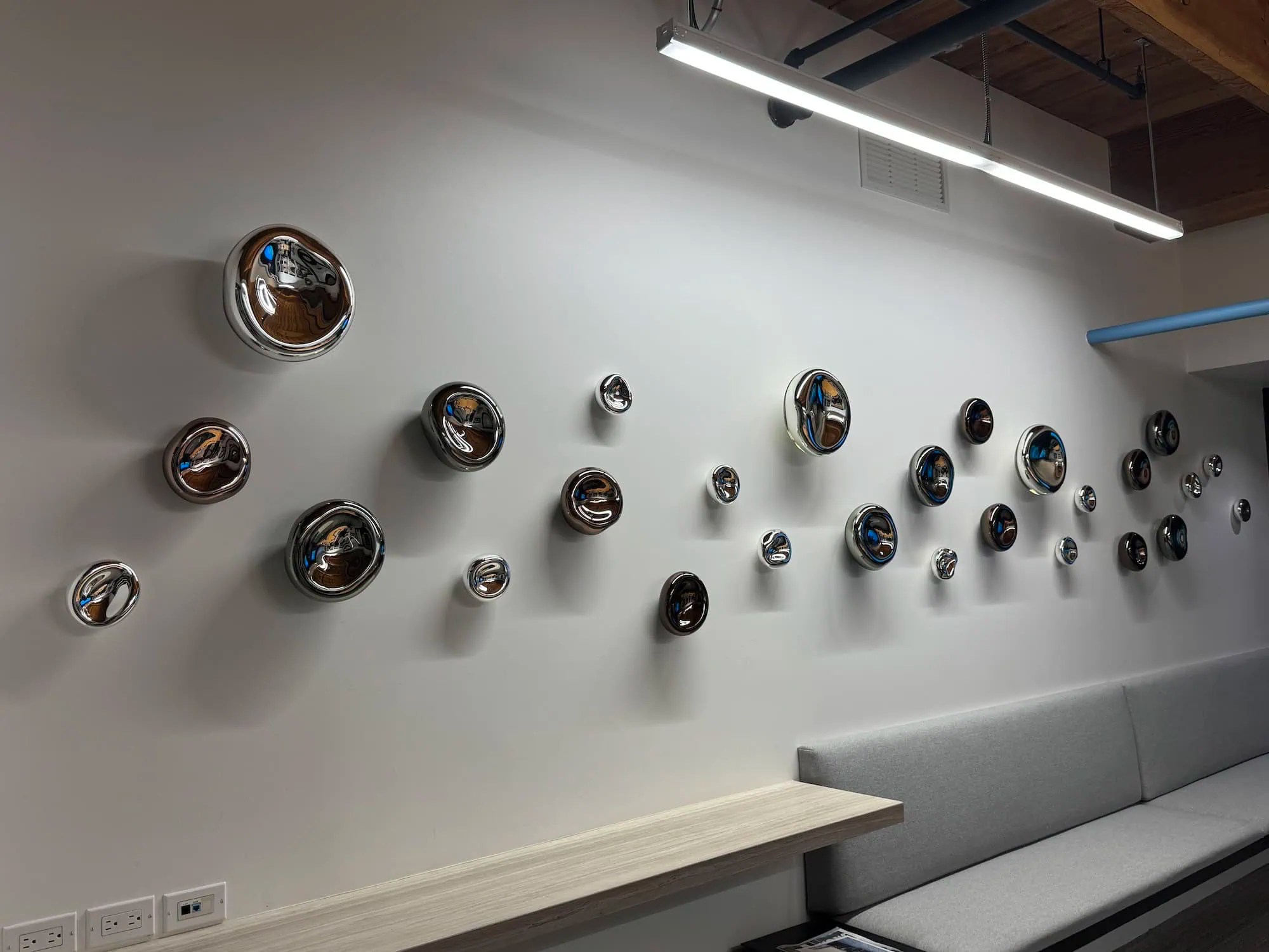 Angled view of Wall Cells in mirrored silver and smokey topaz with exposed wood beam ceiling, SGH Design Partners Toronto 2026