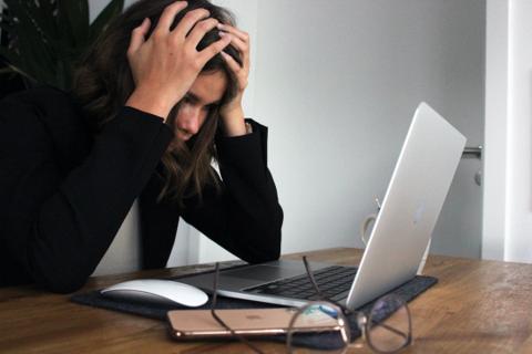 Woman stressed at computer.