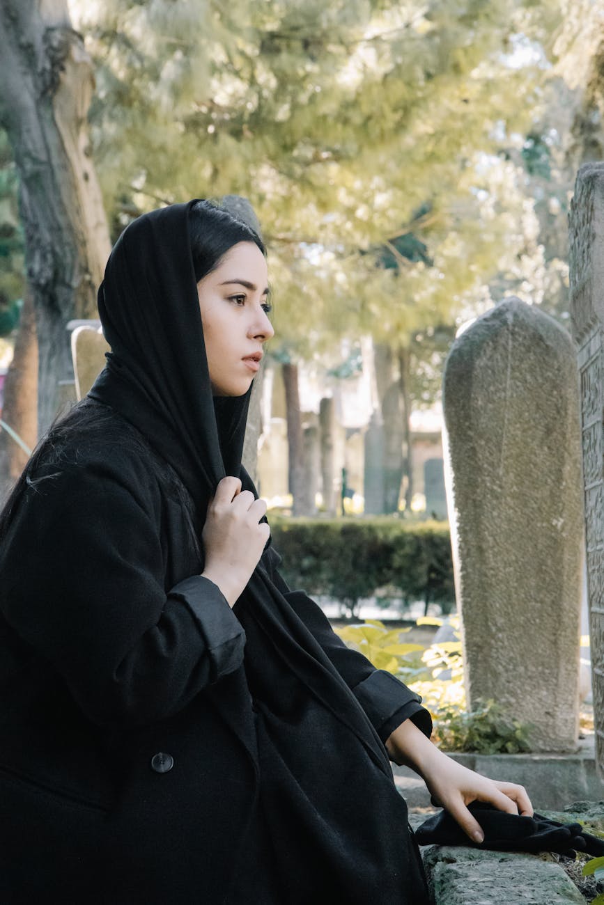 ethnic woman in authentic headscarf on cemetery