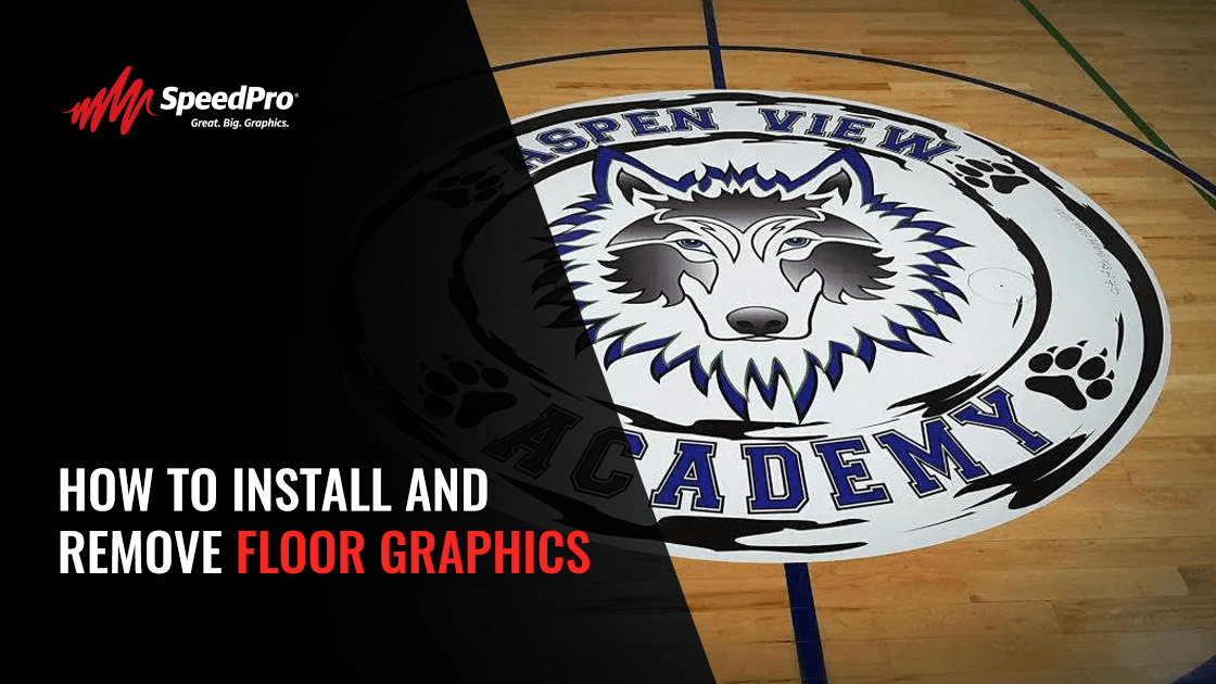 Custom floor decal featuring a wolf mascot installed at center court inside a school gym with caption “Custom Floor Graphics: How to Install, Care for & Remove Them”.