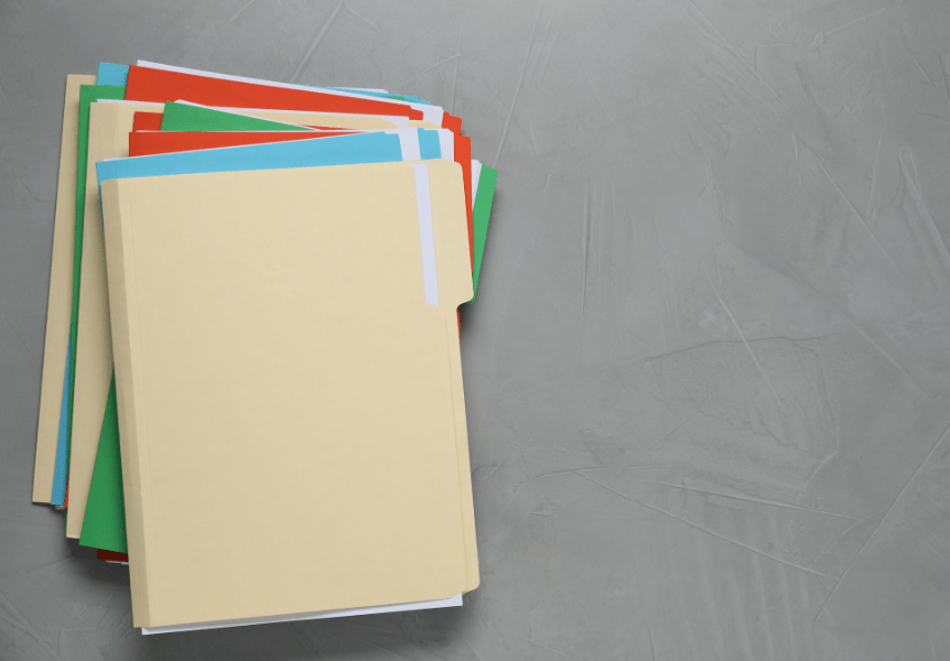 pile of manila folders with red, blue and green inserts.