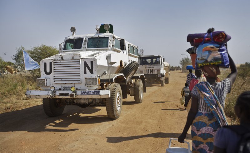 A United Nations armored vehicle passes displaced people walking towards the U.N. Protection of Civilians camp in Malakal, South Sudan on Monday, Dec. 30, 2013 [Photo by Associated Press]