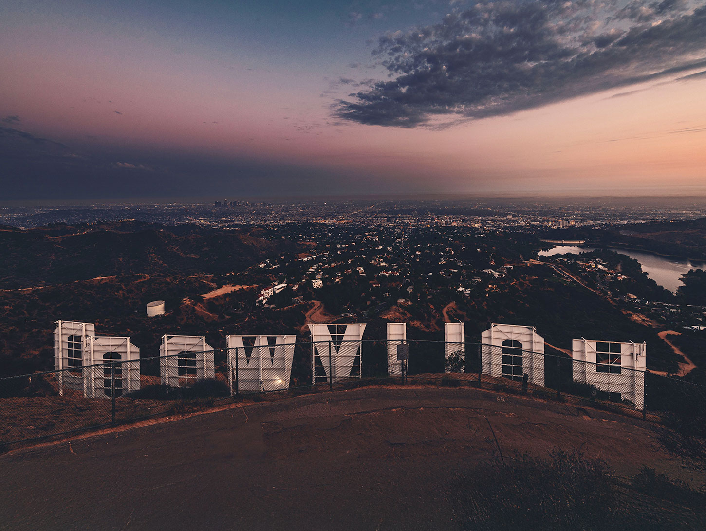 Hollywood sign from behind with view of Los Angeles at twilight