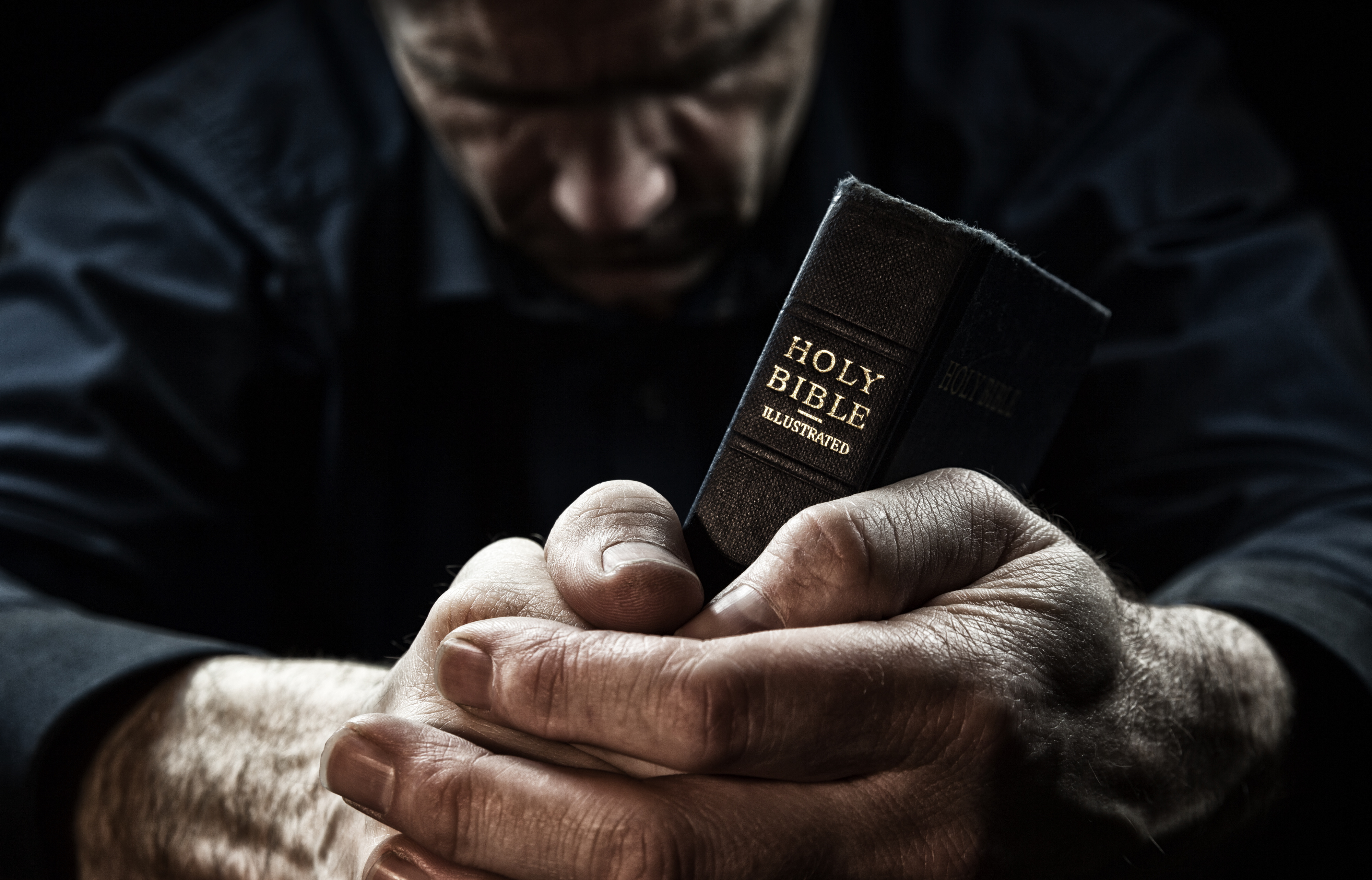 Black Man Praying Under Red Light Free Stock Photo