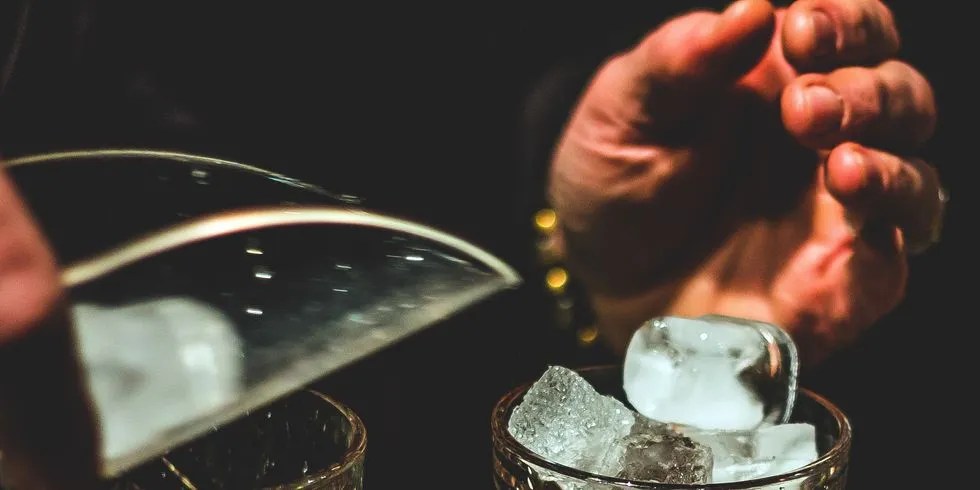 bartender scoops ice for cocktail