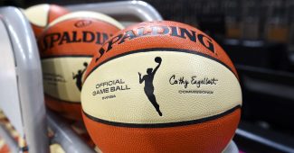 A WNBA branded basketball on a ball rack