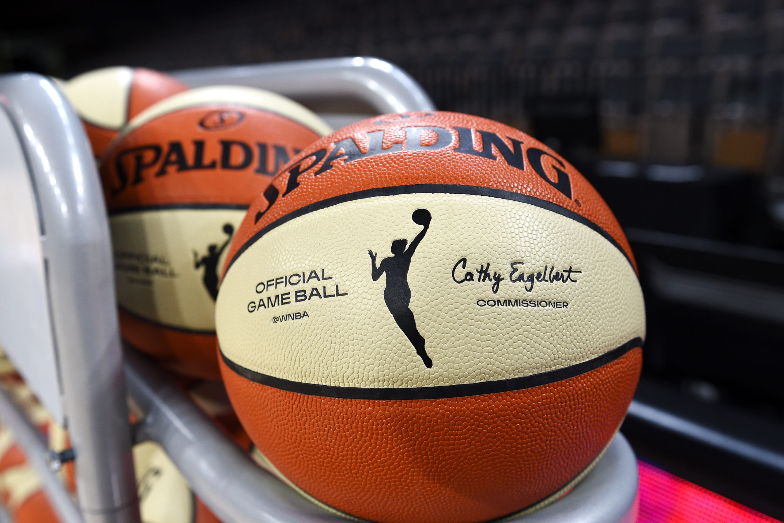 A WNBA branded basketball on a ball rack