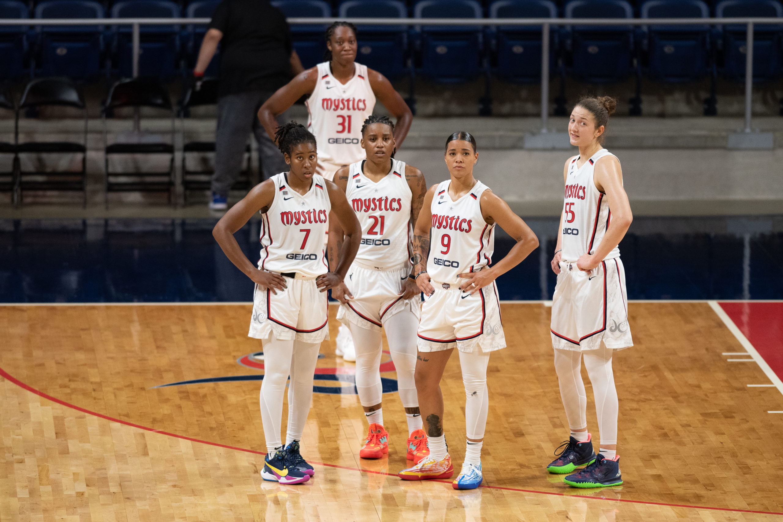 Washington Mystics players Ariel Atkins (7), Tina Charles (31), Shavonte Zellous (21), Natasha Cloud (9) and Theresa Plaisance (55) prepare to resume play during a game against the Phoenix Mercury on May 18, 2021. (Photo credit: Domenic Allegra)