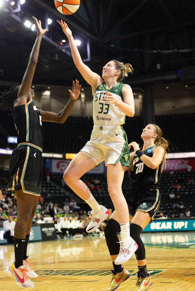 Katie Lou Samuelson blows by Sabrina Ionescu and rises in front of and over a vertically extending Natasha Howard to take a layup