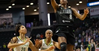 Kennedy Burke goes up for a layup as two defenders right behind her watch