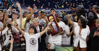 Dawn Staley lifts her arms to the sky as the confetti falls on South Carolina's 2022 national championship.