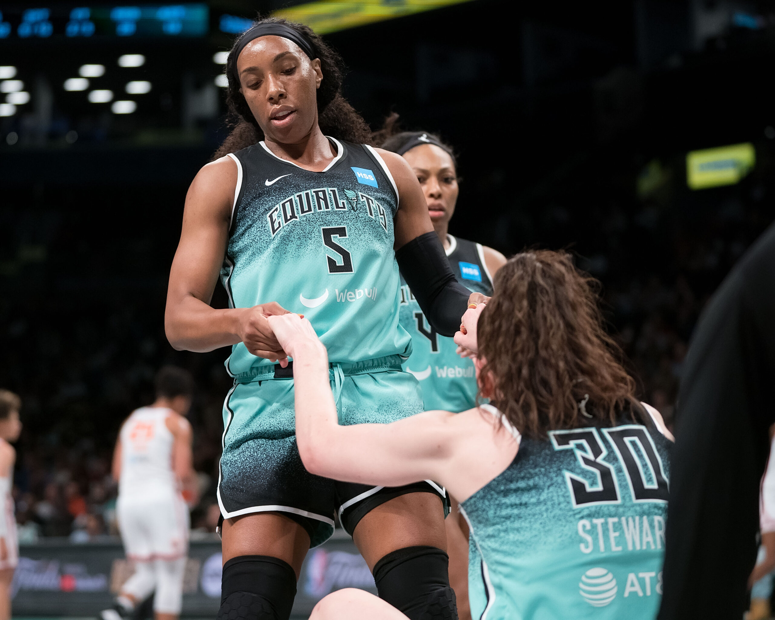 New York Liberty forward Breanna Stewart (30) is helped up by New York Liberty forward Kayla Thorton (5) during the WNBA game between the Connecticut Sun and the New York Liberty at Barclays Center, Brooklyn, New York, USA on May 27, 2023. Photo Credit: Chris Poss