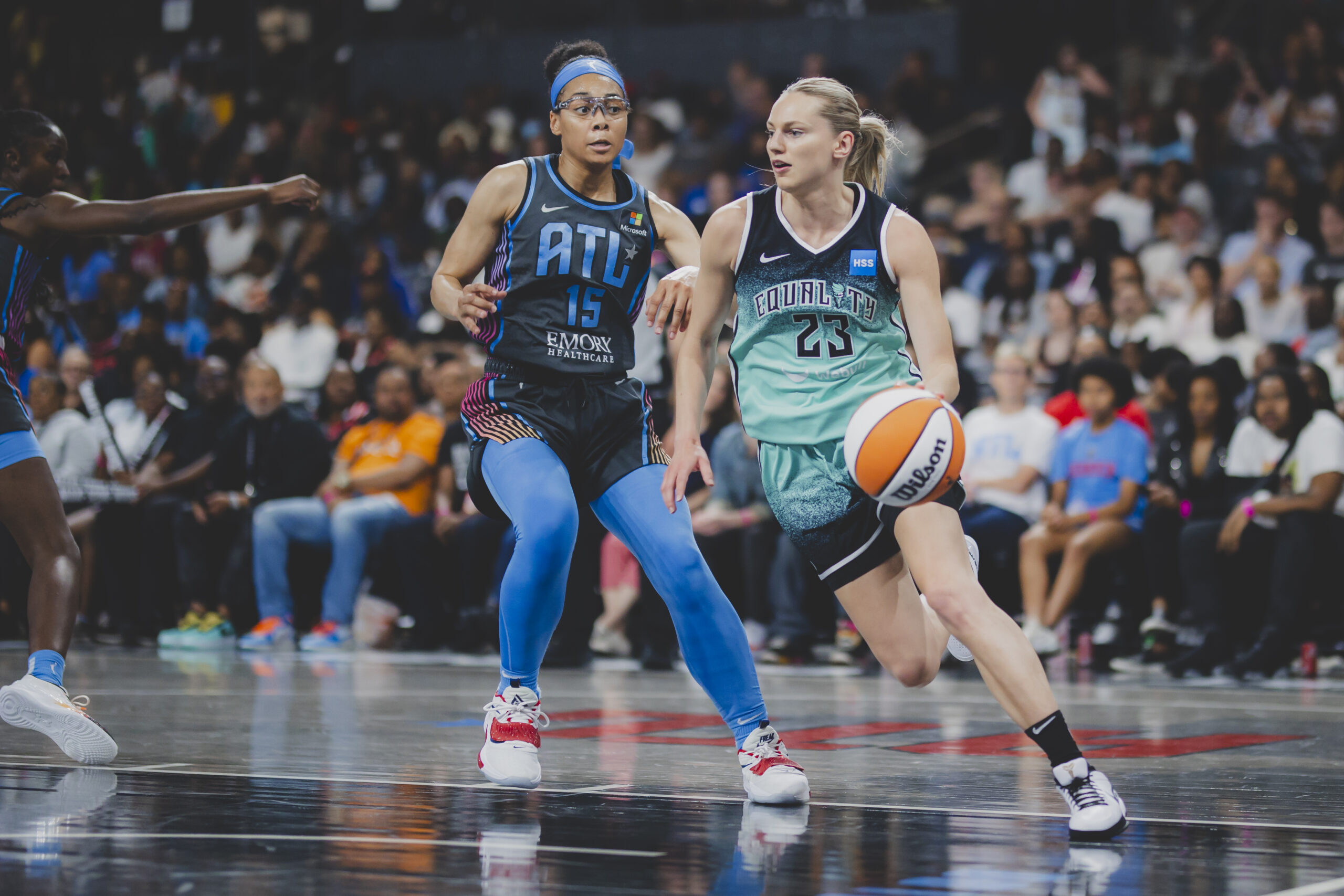 New York Liberty guard Marine Johannès drives with her left hand while Atlanta Dream guard Allisha Gray trails her.