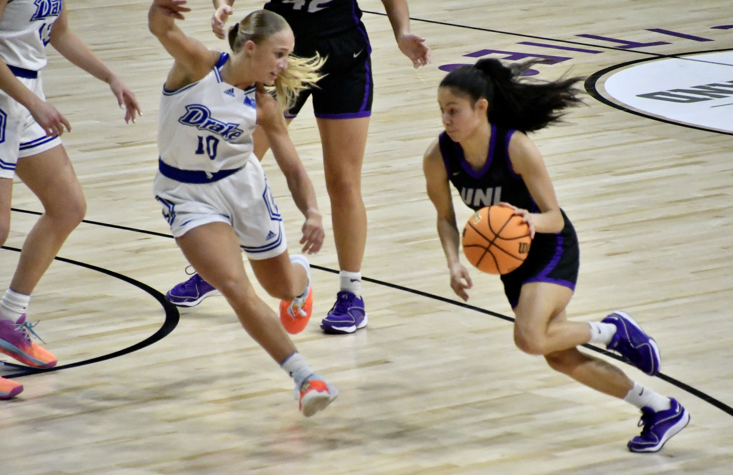 UNI's Maya McDermott drives against Drake's Katie Dinnebier