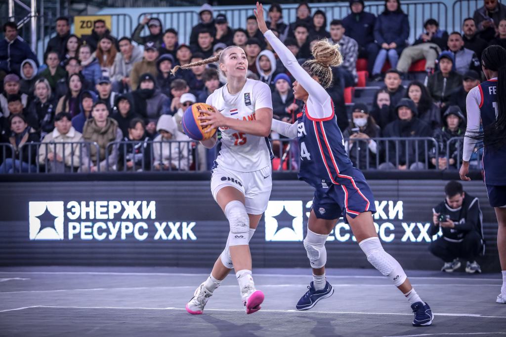 Team USA guard Harmoni Turner extends her left arm up as she slides her feet and tries to keep Netherlands forward Lotte van Kruistum away from the basket.