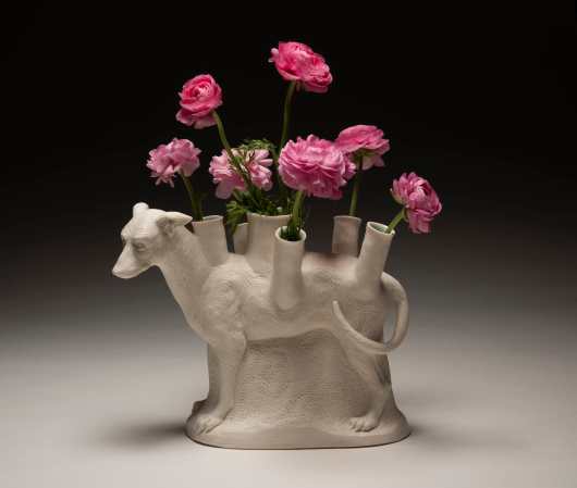A ceramic sculpture of a dog with flower vases on its back.