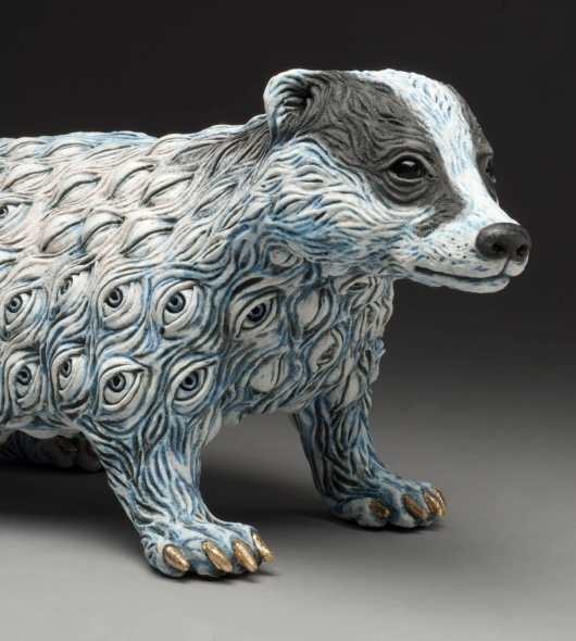 A detail of a ceramic sculpture of a badger with fur made of eyes.