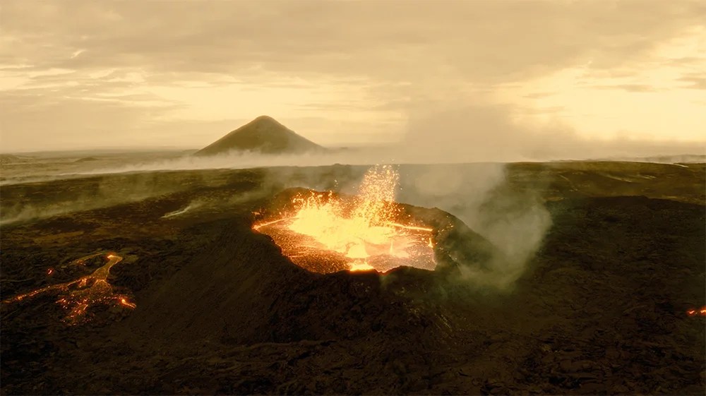 A volcano erupting, spewing bright orange lava and thick gases under a cloudy, yellow-tinged sky.