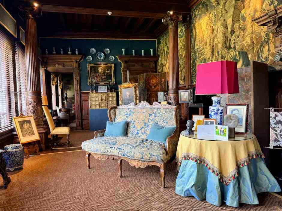 tapestry covered walls and antique furnishing in a room