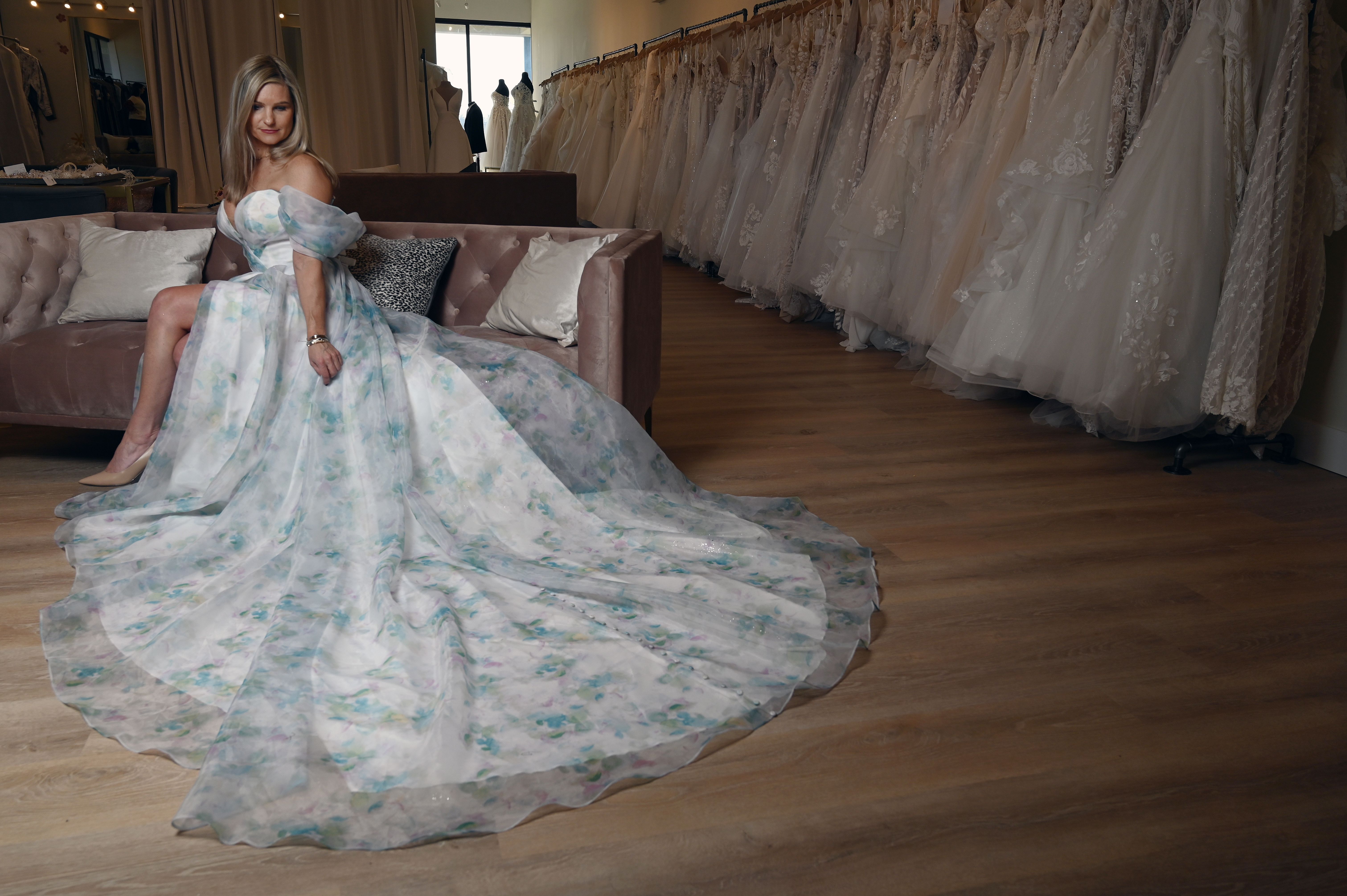 Amanda Ritchey, owner of Amanda's Bridal Loft of Annapolis, wears a La Perle by Calla Blanche floral wedding dress made of Organza with sweetheart neckline, off the shoulder sleeves and a slit. (Kim Hairston/Baltimore Sun)