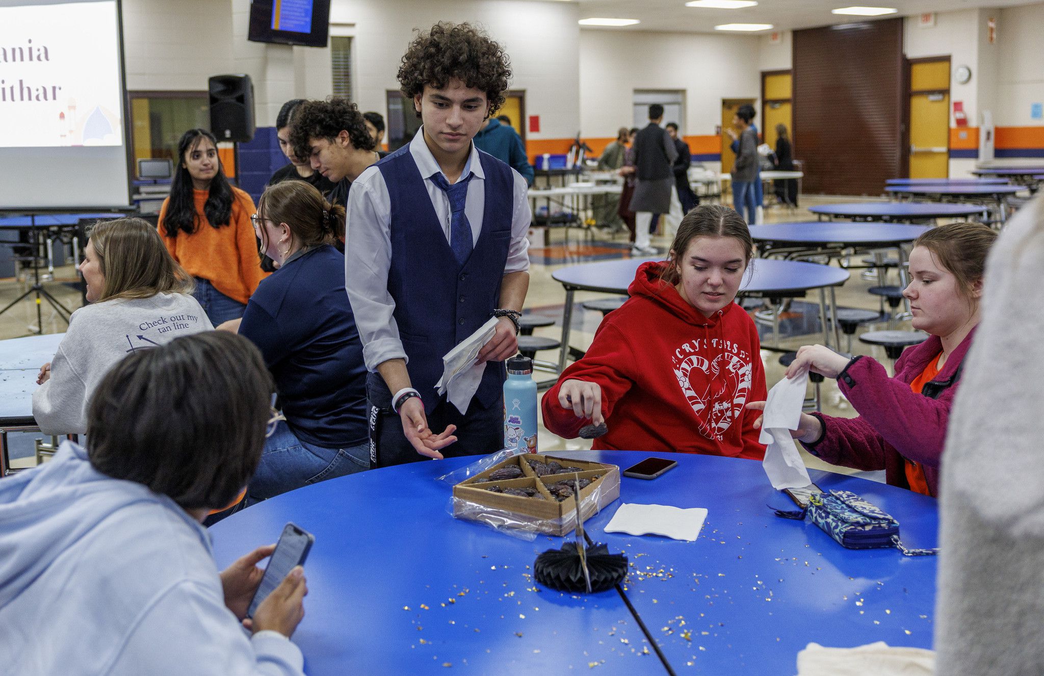 Abdullah Abouhaiba, 15, passes out dates during an iftar Ramadan dinner fast-a-thon at Oswego High School, April 5, 2023, in Oswego, Illinois. During the day, Muslim students from Oswego High School invited non-Muslim students to join their fast for the day and participate in an iftar, breaking of the fast meal. (Armando L. Sanchez/TNS/Chicago Tribune)