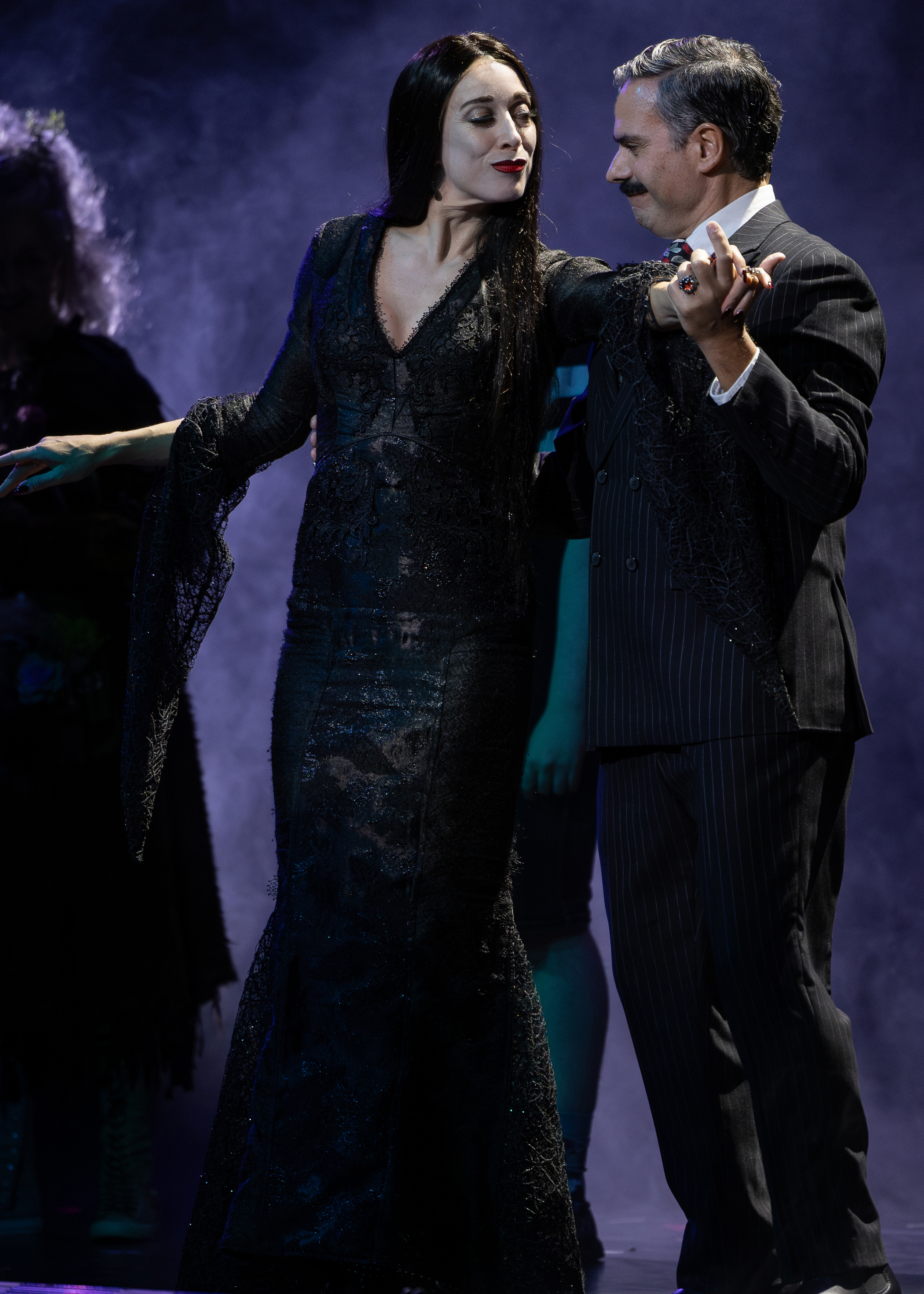 Gomez holds Morticia in his arms as if they are dancing.