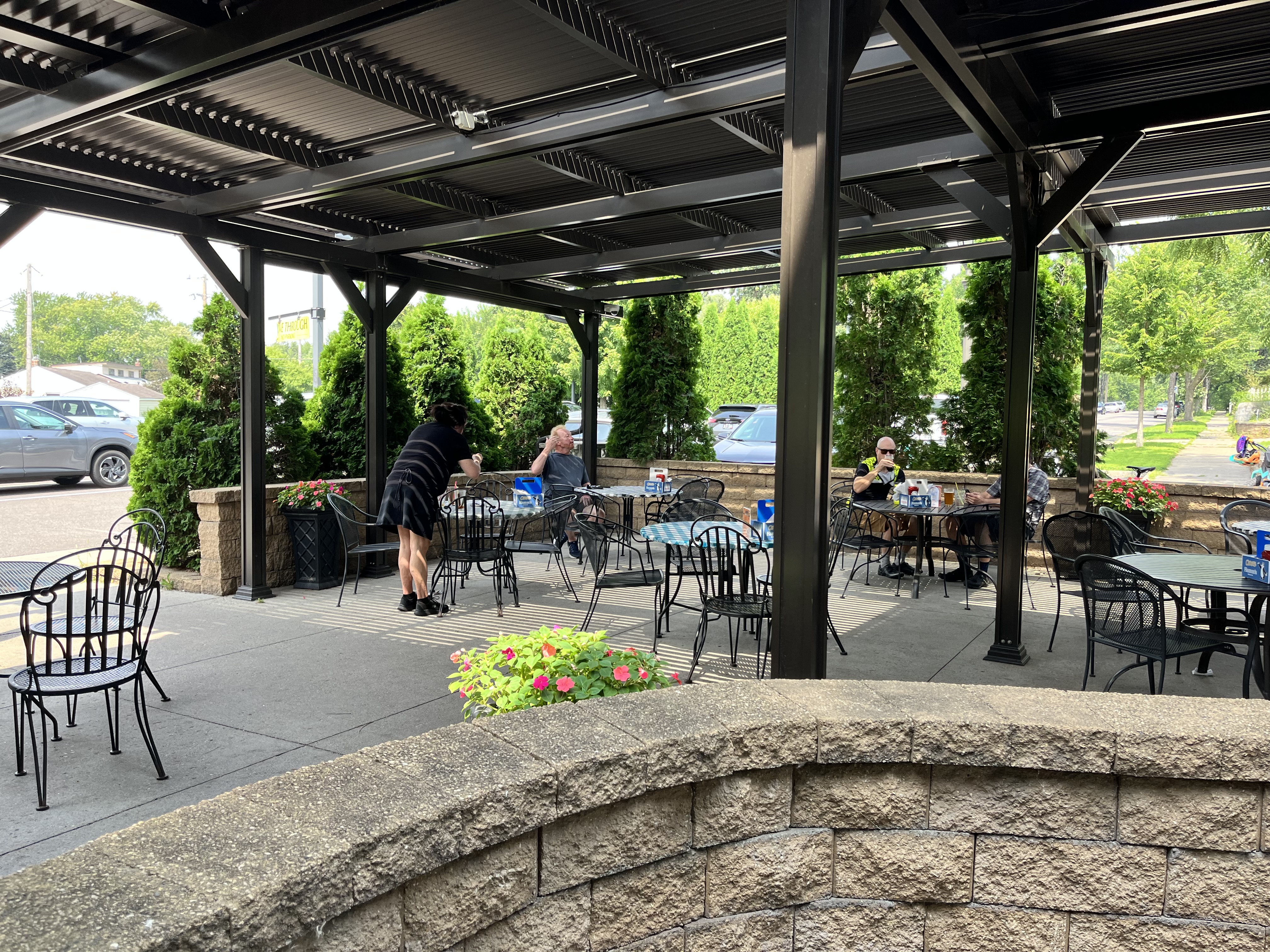A patio with a metal pergola and roof