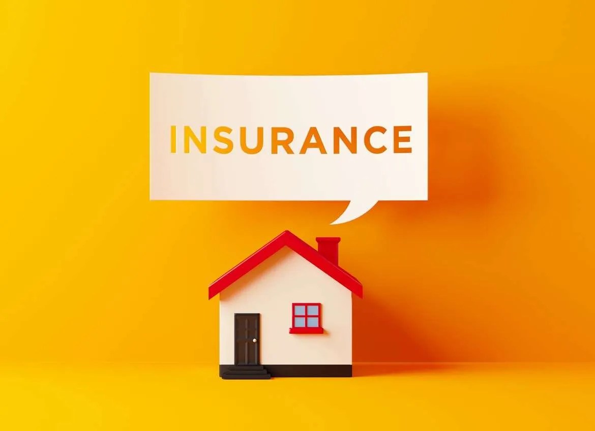 Toy-sized house with the word insurance above it.