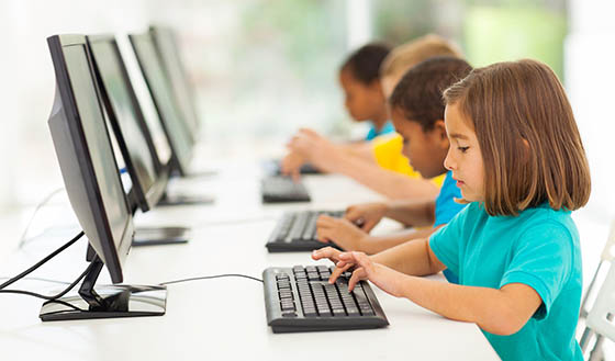 group elementary school students in computer class