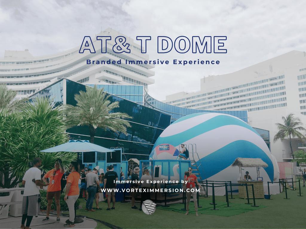 Group of people at an outdoor branded immersive experience near a large blue-and-white inflatable dome, with palm trees and a modern building in the background; 'AT&T DOME' signage visible.