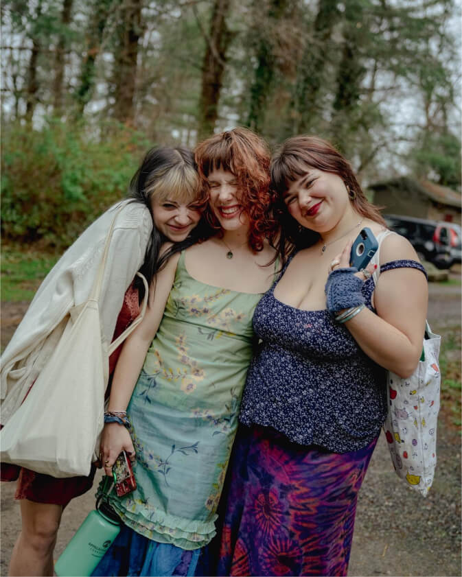 A group of three smiling students huddle together for a picture.