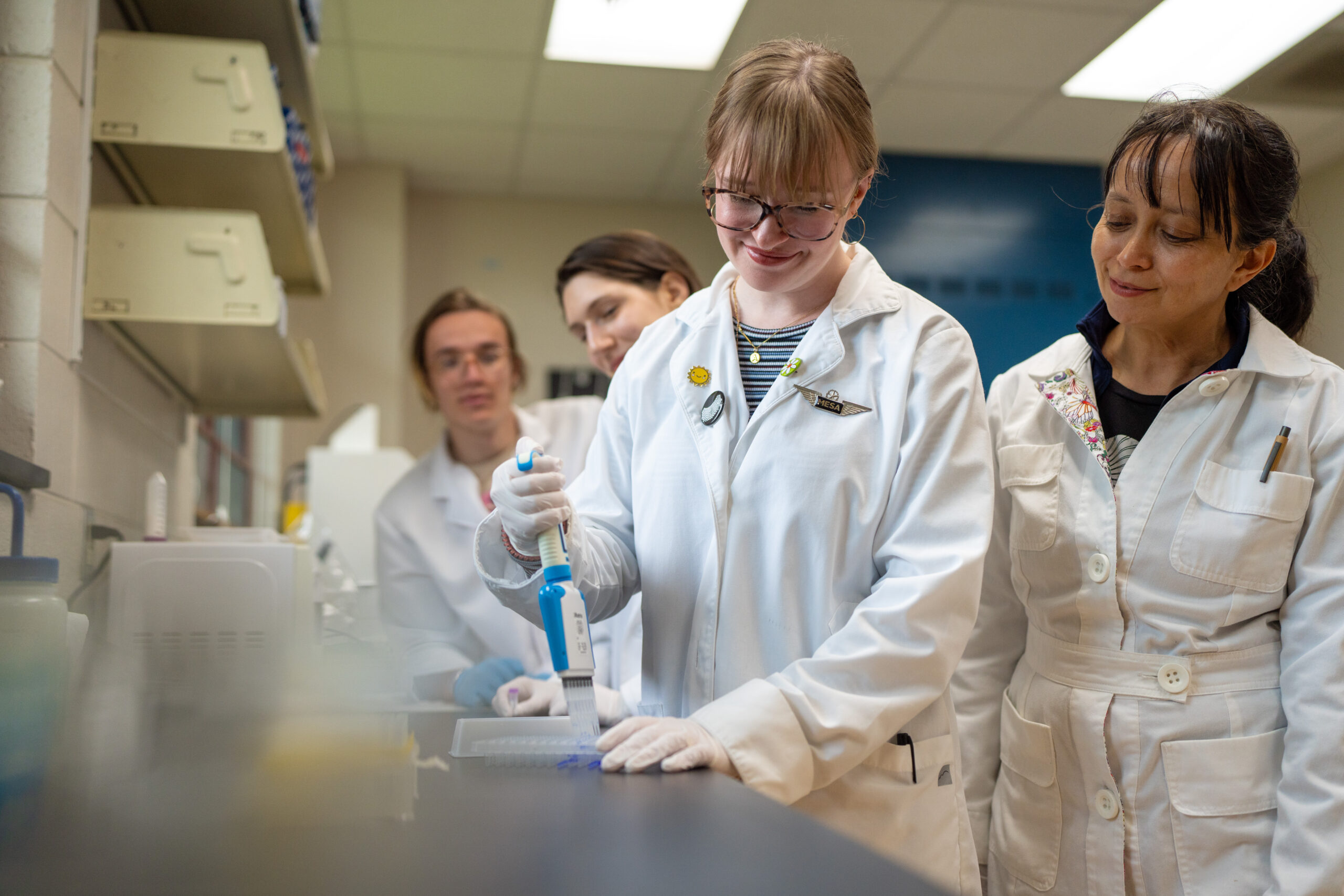 A group of students alongside Dr. Alisa Hove work in the genetics lab