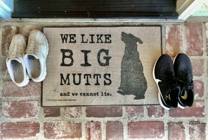 Welcome mat reading: "We like big mutts and we cannot lie" with silhouette of large dog.