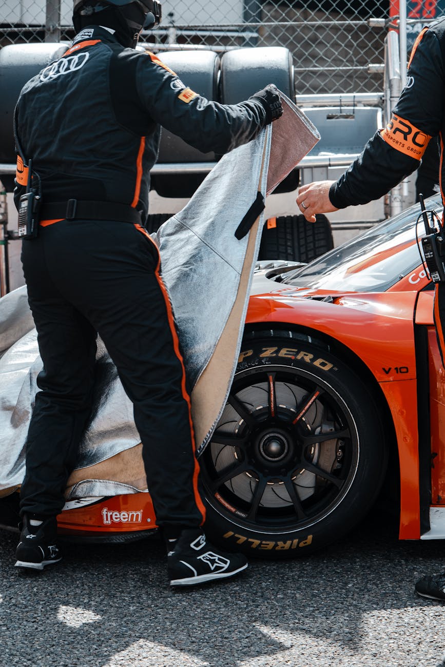 person putting a cover on a sports car