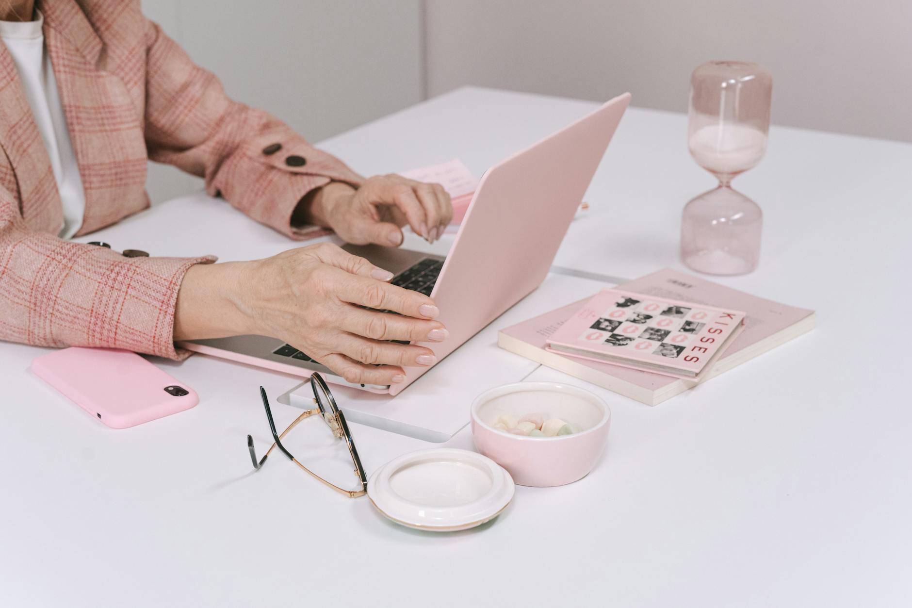 person using a macbook with pink case