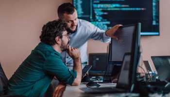 Programmers engrossed in deep collaboration, diligently working together to solve complex problems and develop innovative mobile applications with seamless functionality.