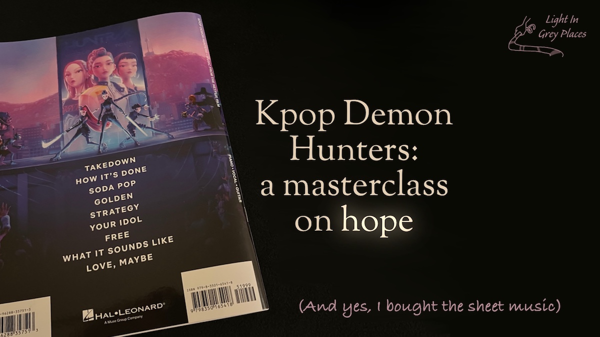 Picture of the back cover of the book of sheet music for the Netflix film Kpop Demon Hunters, published by Hal Leonard, against a black background. Feature text: Kpop Demon Hunters: a master class on hope (and yes I bought the sheet music) | Light in Grey Places.