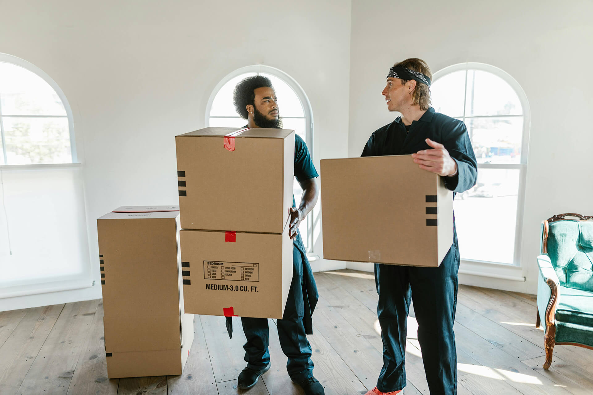 Two long-distance movers carrying boxes