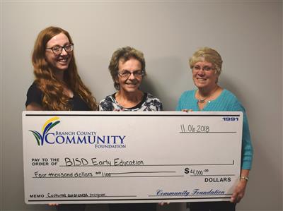 3 womesn holding large check