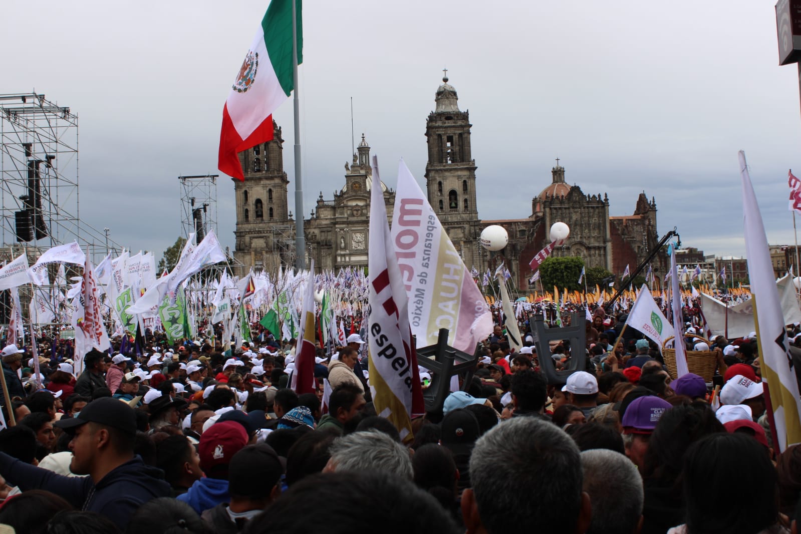Gorras, banderas y playeras blancas, guinda e incluso un naranja que desentona. La plancha del Zócalo está desbordada.