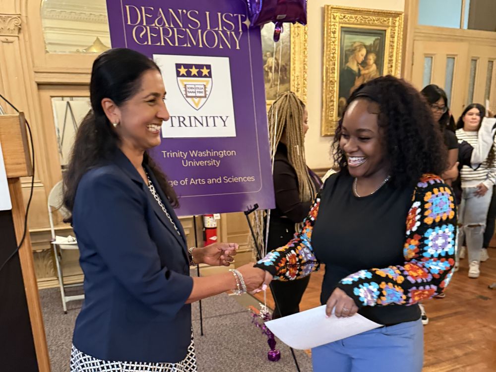 Dean Sita Ramamurti presents a certificate to a Dean's List student